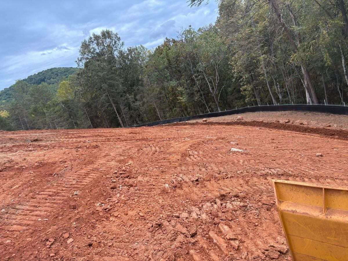 Freshly graded pad with super silt fence along the tree line at the Afton solar site
