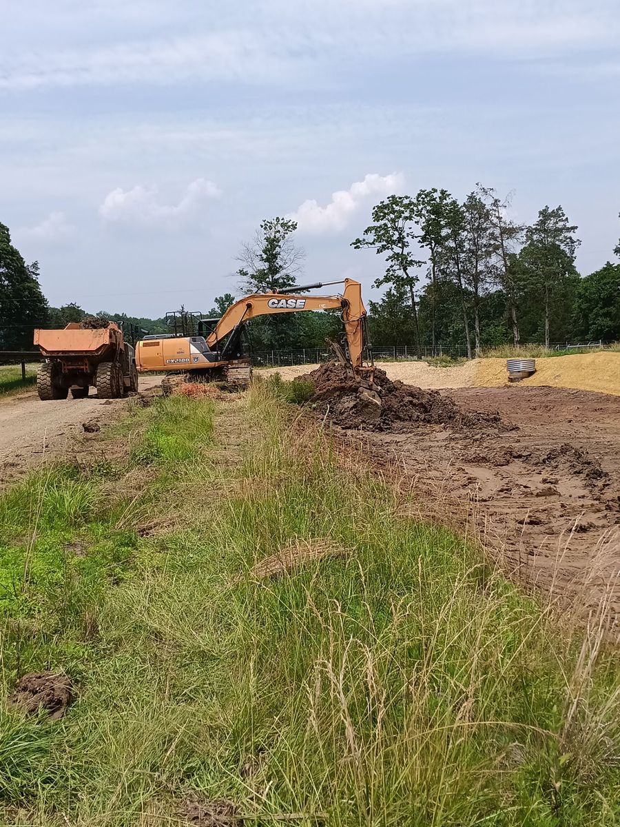 Excavator cutting grade along the edge of an active work area
