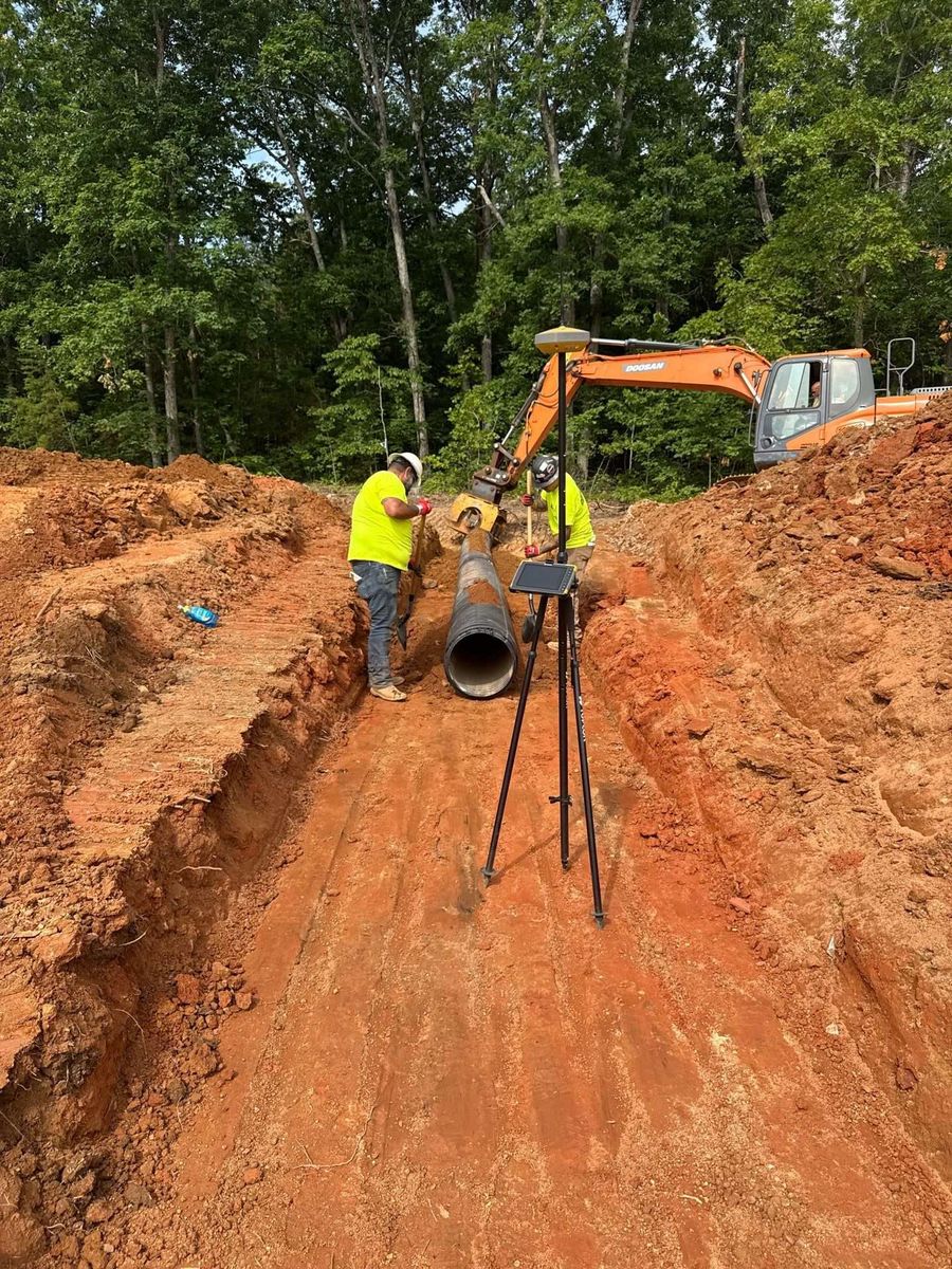 Crew installing stormwater pipe in a prepared trench