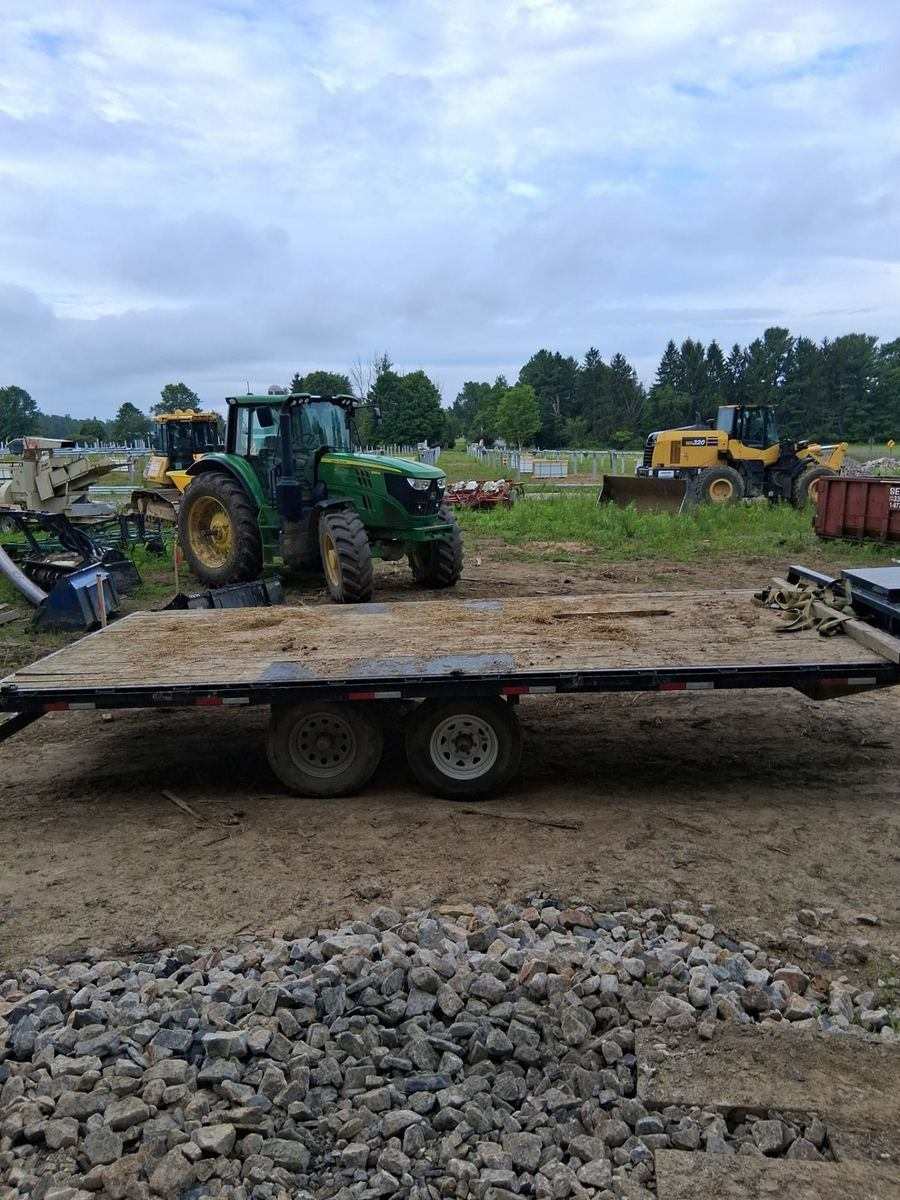 Tractor and flatbed trailer staged with site equipment